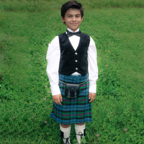A young boy wearing a Quality Wool Blend Kilt for Kids stands confidently in a field.