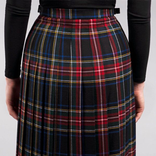 The back view of a woman wearing a plaid skirt.