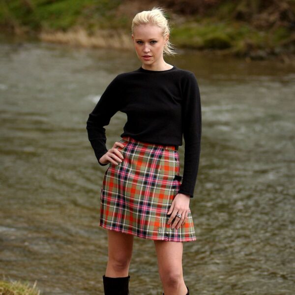 A woman in a plaid skirt standing by a river wearing the Light Weight Premium Wool Kilted Mini Skirt.