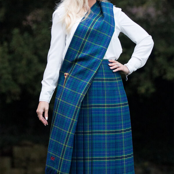 A woman wearing a Welsh Tartan Medium Weight Premium Wool Traditional Sash with a medium weight.