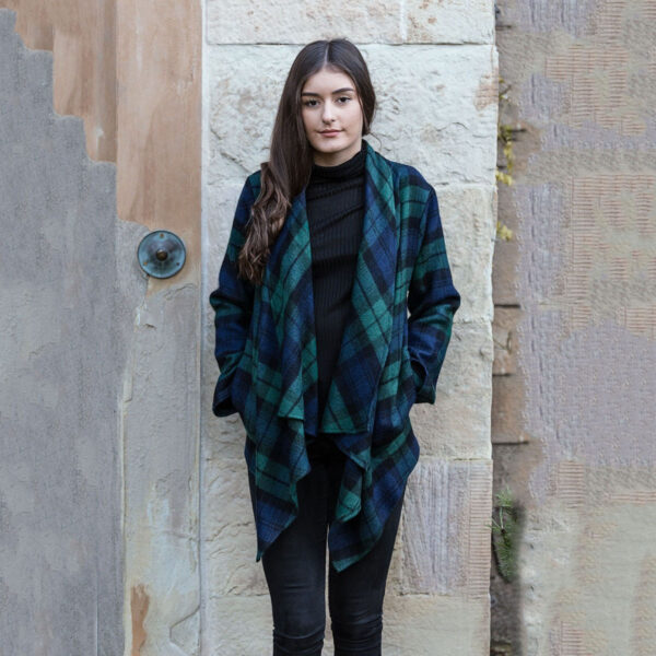 A woman donning a green and black Scottish Lambswool Tartan Kerry Jacket.