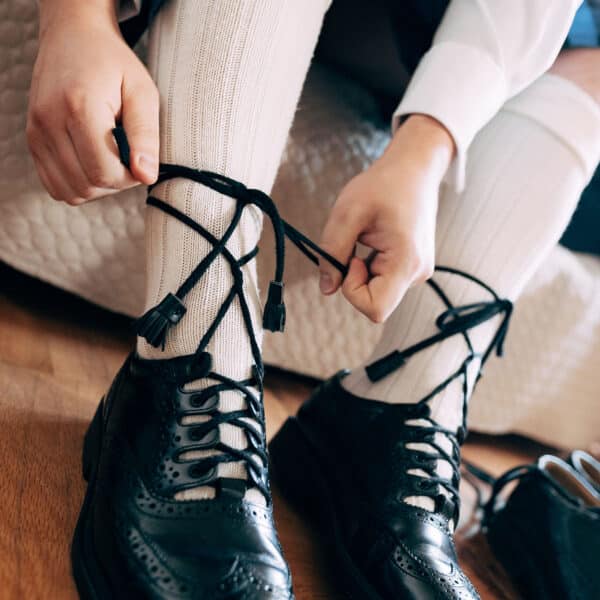 A person tying a pair of black shoes.