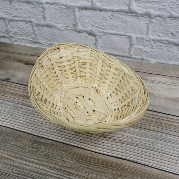 A small Bamboo Basket sitting on a wooden table.