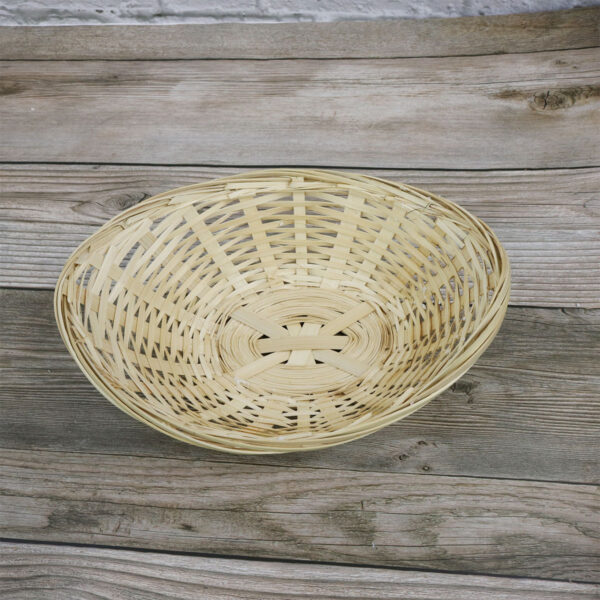 A small Bamboo Basket sitting on top of a wooden table.