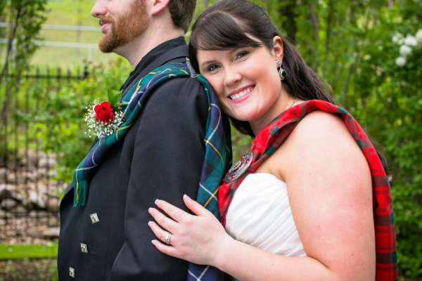 A bride and groom posing for a photo in a kilt adorned with a Light Weight Premium Wool Tartan Sash.