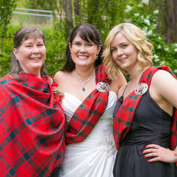 Three bridesmaids posing for a photo in a Light Weight Premium Wool Tartan Sash.