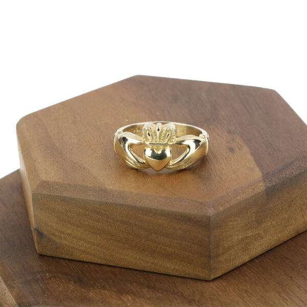 A Womens 10K Gold Claddagh Wedding Ring - Size 7 delicately placed atop a wooden box.