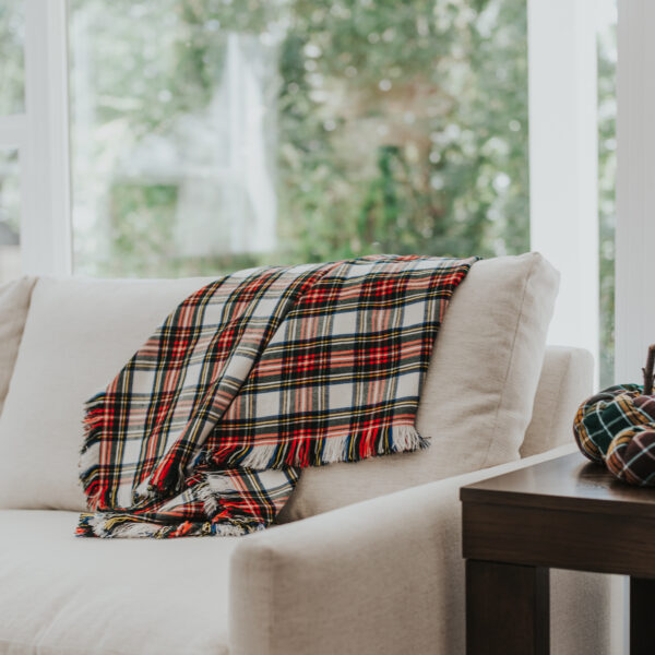 A Homespun Tartan Blanket/Throw on a white couch.