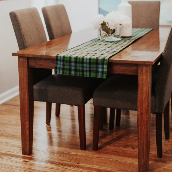A Reversible Tartan Placemat - Homespun Wool Blend on a wooden table.