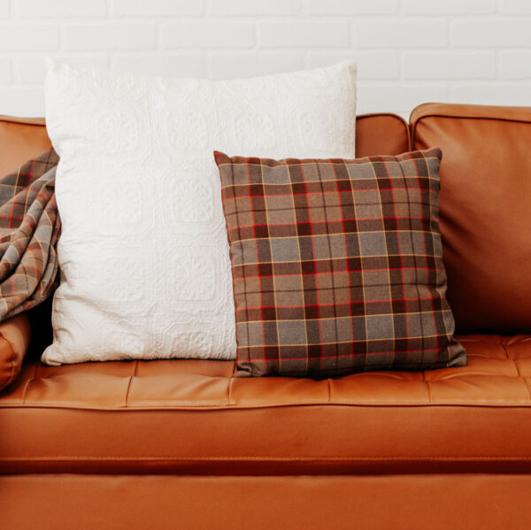 A brown couch with OUTLANDER Throw Pillow Cover Authentic Premium Wool Tartan throw pillows.