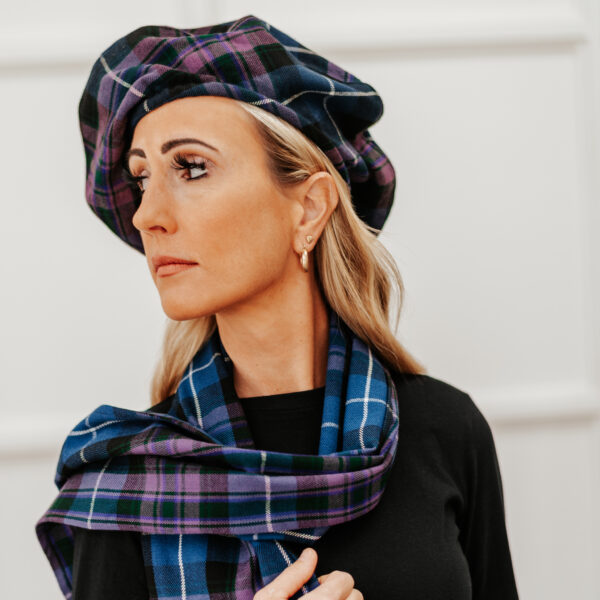 A woman wearing a Quality Wool Blend Kilt with Matching Tartan Flashes and FREE Kilt Hanger, looking cozy in her homespun attire.