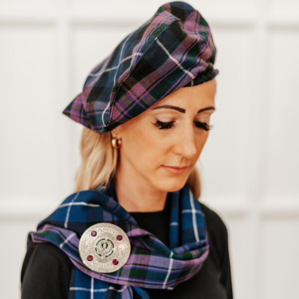A woman wearing a Scottish tartan beret in a Quality Wool Blend Kilt with Matching Tartan Flashes and FREE Kilt Hanger.