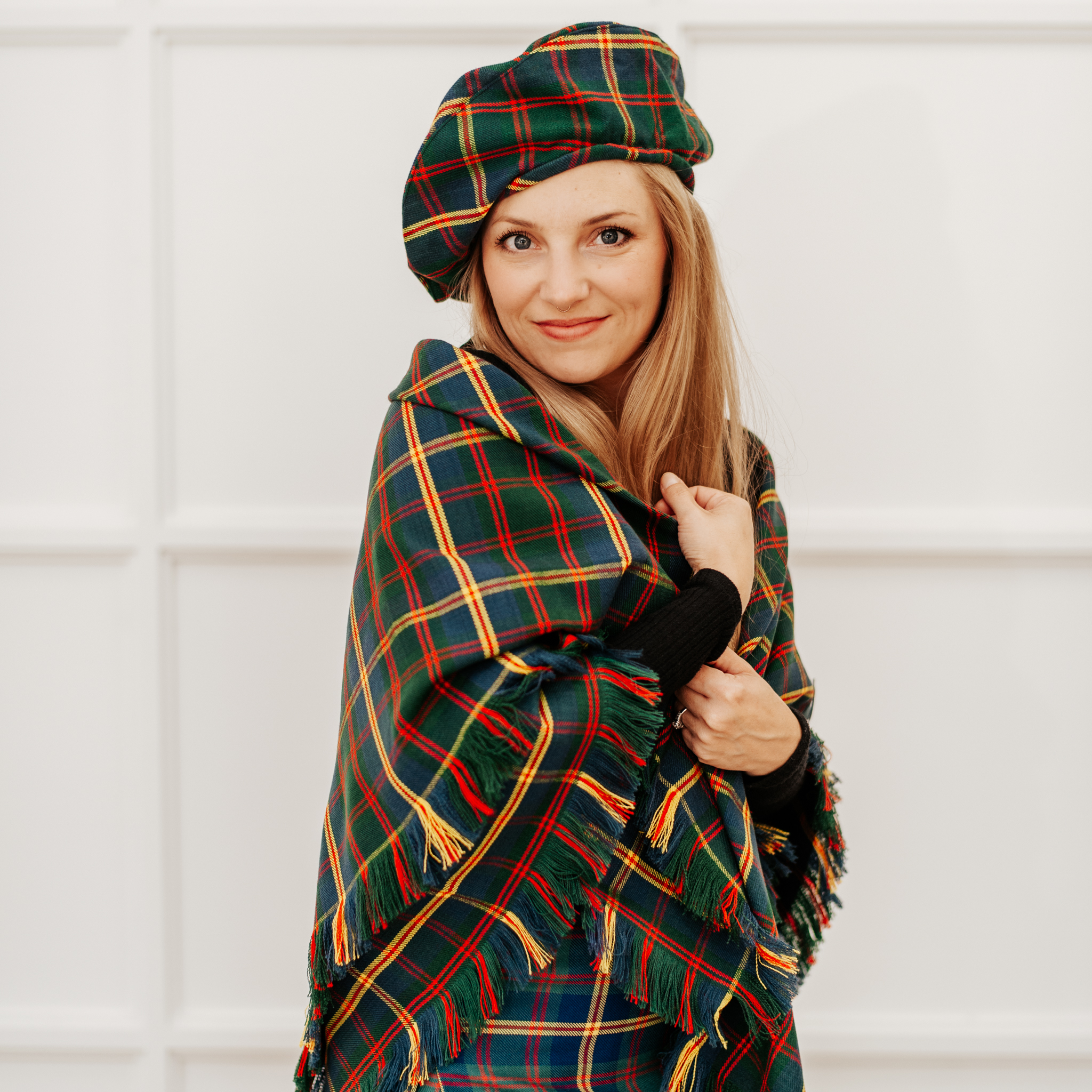 A woman wearing a Quality Wool Blend Kilt with Matching Tartan Flashes and FREE Kilt Hanger hat.
