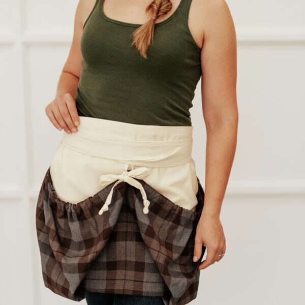 A woman wearing a plaid apron.