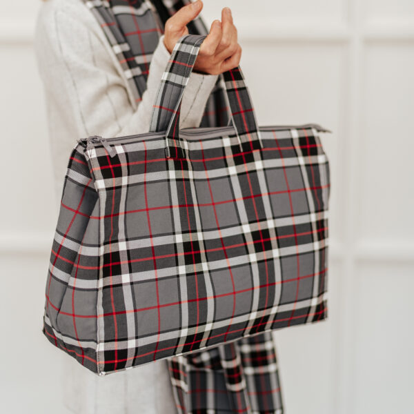 A woman carrying a Tartan Purse - Poly/Viscose Wool Free in a grey and black plaid design.