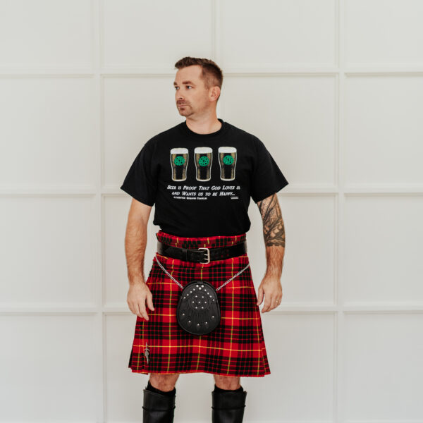 A man in a Quality Wool Blend Kilt with Matching Tartan Flashes and FREE Kilt Hanger is standing in front of a white wall.
