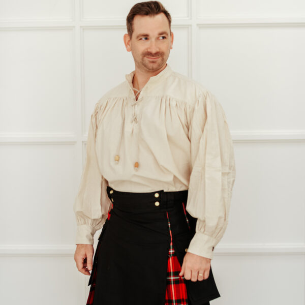 A man in a Hybrid Canvas and Tartan Utility Kilt - Bundle standing in front of a white wall.