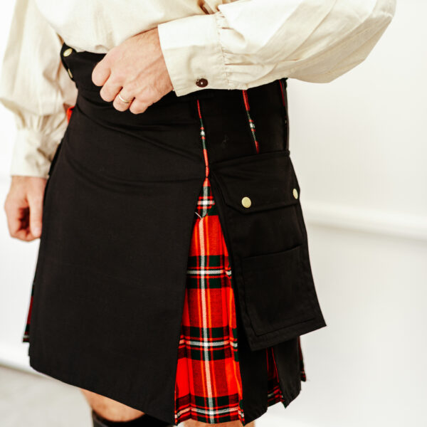 A man wearing the Hybrid Canvas and Tartan Utility Kilt - Bundle made of a wool blend fabric in black and red.
