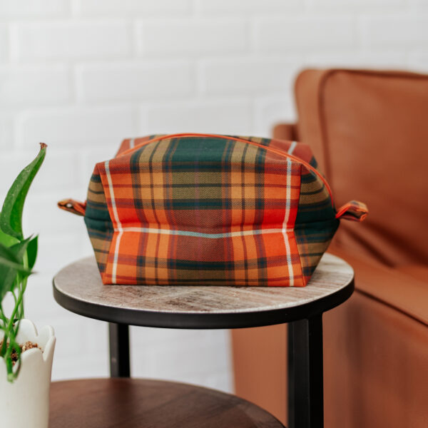 A small round table with a Tartan Purse - Poly/Viscose Wool Free on it.