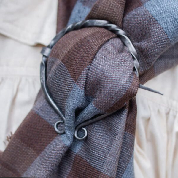 A brown plaid scarf with a metal ring on it.