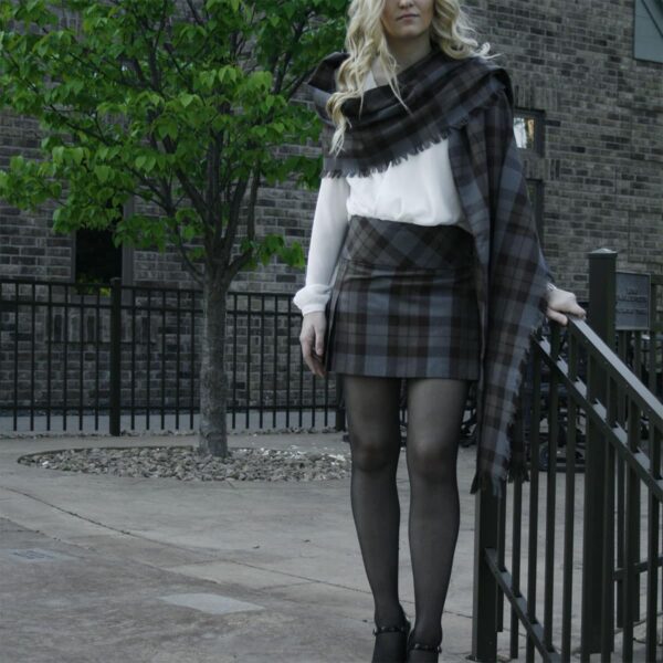 A blonde woman in a plaid skirt posing for a picture wearing an OUTLANDER Billie-Style Kilted Mini-Skirt Poly/Viscose.