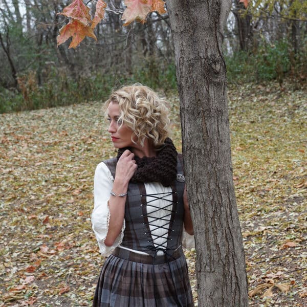 A woman in an elegant dress leaning against a tree, wearing the OUTLANDER Inspired Custom-Made Hand-Knit Cowls.