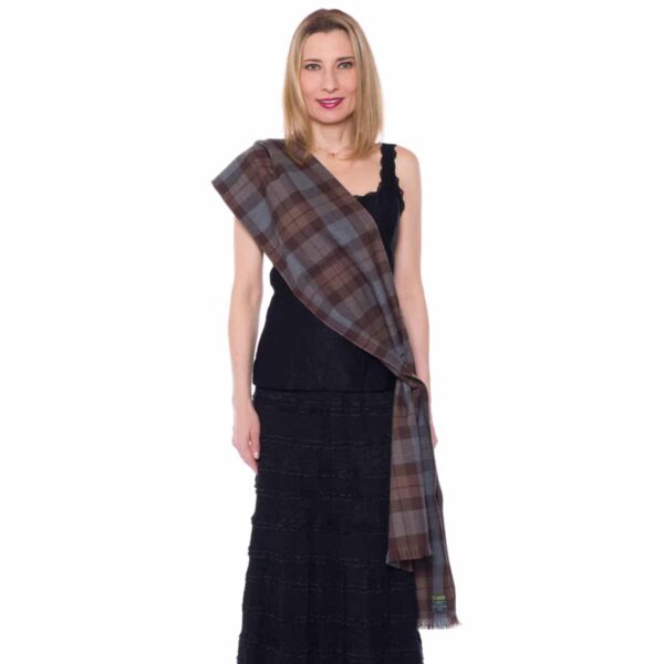 A woman in a black dress wearing a plaid scarf.