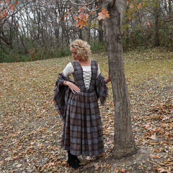 An OUTLANDER Inspired Custom-Made Hand-Knit Cowls woman in a renaissance dress leaning against a tree.