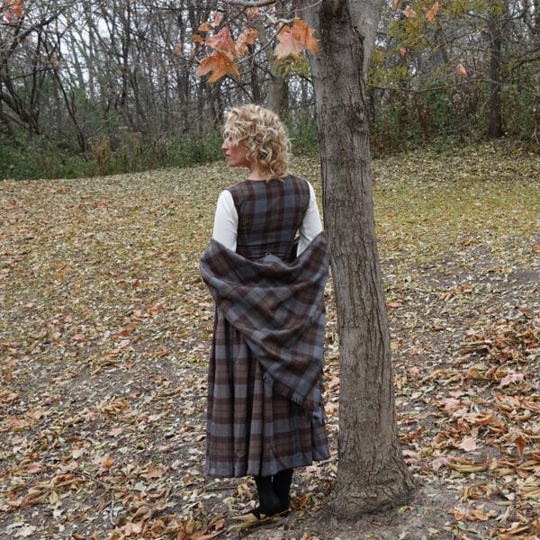 A woman in a plaid dress standing next to a tree wearing an OUTLANDER Inspired Custom-Made Hand-Knit Cowl.