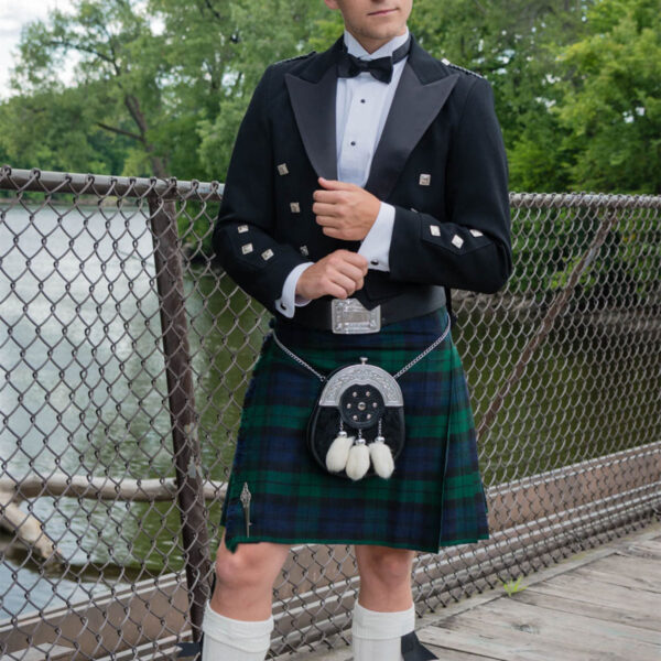A man in a kilt, wearing the Prince Charlie Formal SILVER Package, standing on a bridge.