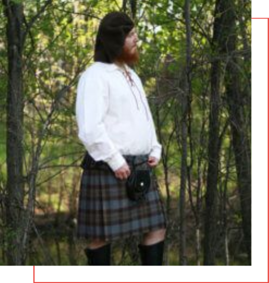 A man in a kilt, exemplifying the perfect attire for traditional Scottish events, confidently standing amidst the serene beauty of the woods.
