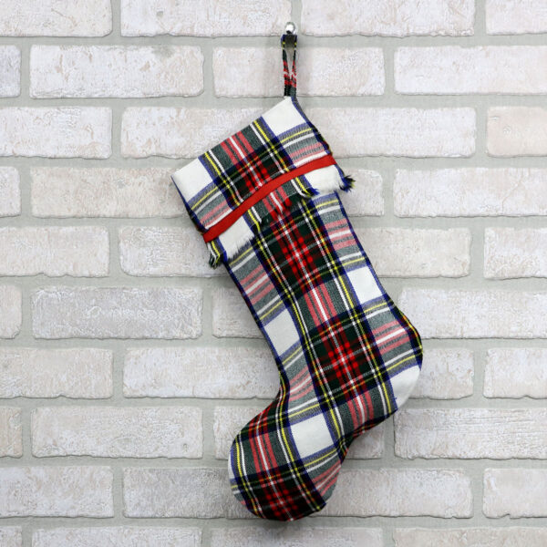 An All Tartan Stocking - Homespun Wool Blend hanging on a brick wall.