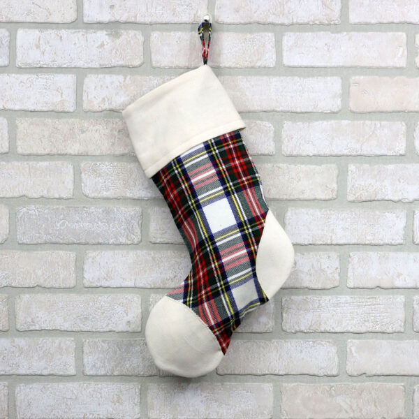 A plaid Tartan Stocking with Toes - Homespun Wool Blend hanging on a brick wall.