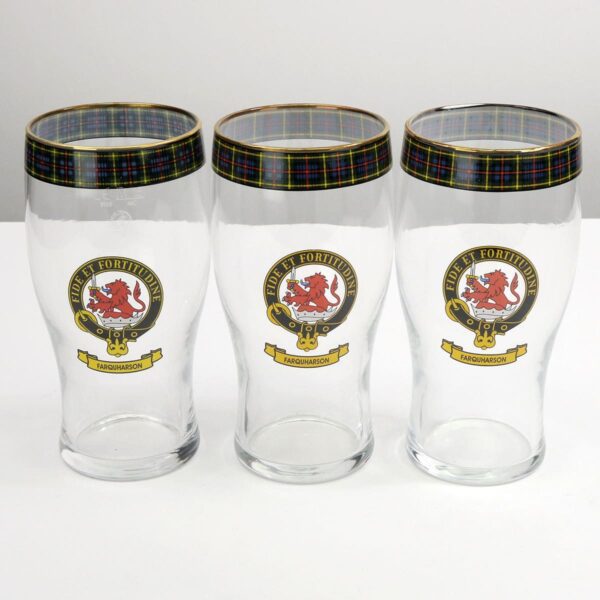 Three pint glasses with a scottish crest on them.