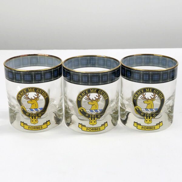 Three glass tumblers with a scottish crest on them.