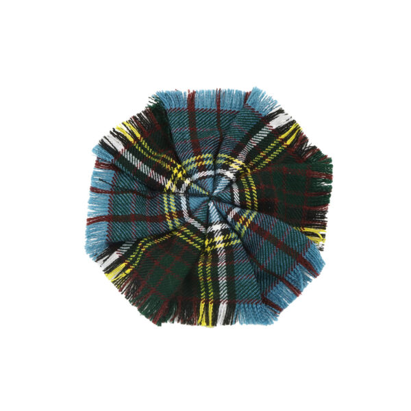 A blue, green, and yellow fringed tartan rosette made from homespun wool blend on a white background.
