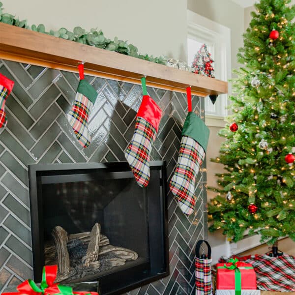 A fireplace with Tartan Stocking - Homespun Wool Blend stockings and presents in front of it.