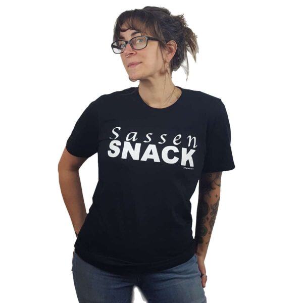 A woman wearing a black t - shirt that says sassen snack.