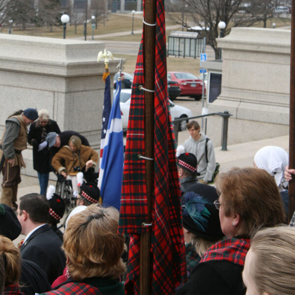 A group of Medium Ancient Kid Kilts, holding flags, dressed in ancient kilts.