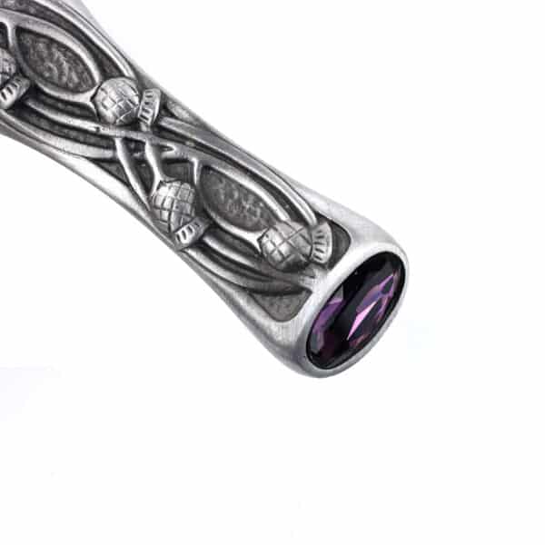 A Pewter Scottish Thistle Knot Sgian Dubh with a purple stone on it.