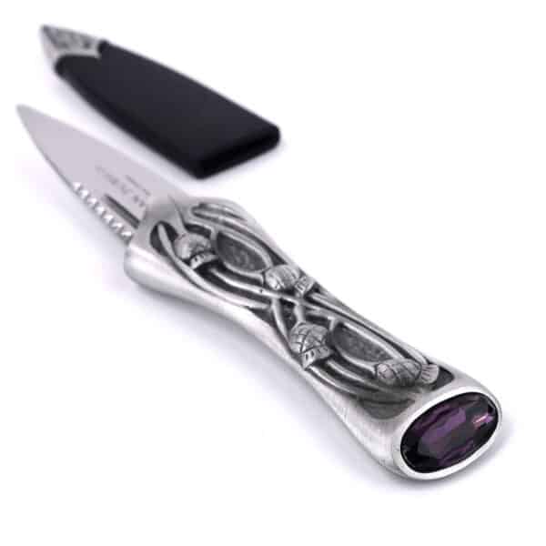 A Pewter Scottish Thistle Knot Sgian Dubh with a purple stone on it.