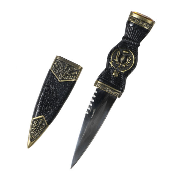 A Thistle Sgian Dubh Bronze Finish Yellow Gem Top on a white surface.