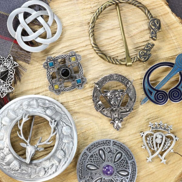 A collection of brooches on a wooden table.