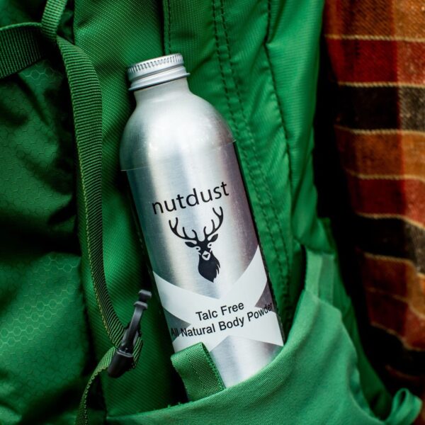 A bottle of Nutdust - Laddie tucked securely in the pocket of a backpack.