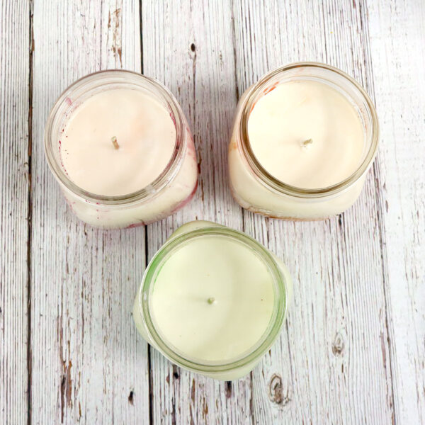 Three Homemade Candles on a wooden table.