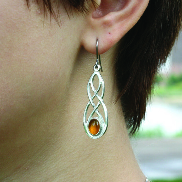 A woman wearing a pair of Cornish Pewter Earrings with Real Amber.
