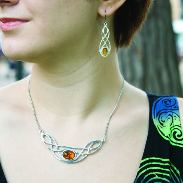 A woman wearing Cornish Pewter Earrings with Real Amber.