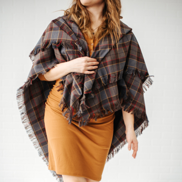 A woman in a brown dress wearing an OUTLANDER Wrap Premium Lambswool Tartan.