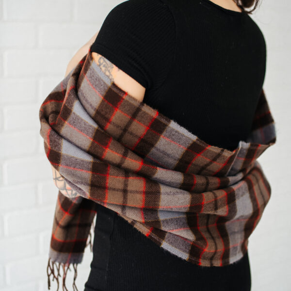 A woman wearing a brown and grey plaid scarf.