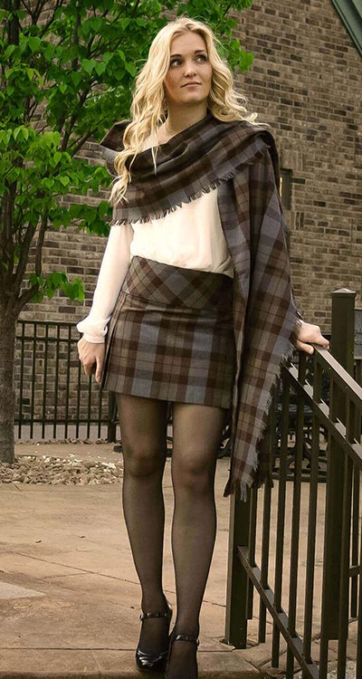 A Scottish woman in a plaid skirt posing for a picture.